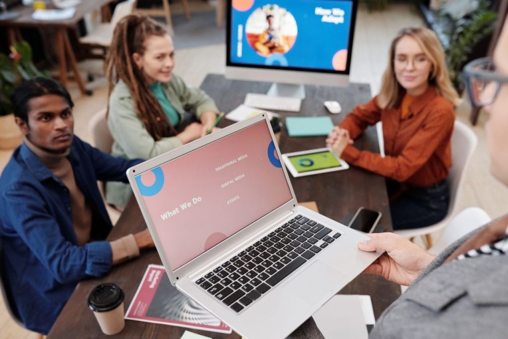 Mastering the First Impression: Your intriguing post title goes here Team collaboration in an office setting with a laptop presentation and diverse colleagues.